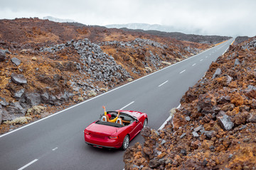 Landscape view on the beautiful straight road on the volcanic valley with woman driving a red...