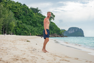 Portrait beau gosse charmant jeune homme caucasian blond aux yeux bleu joyeux confiance en soi...