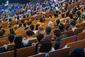 Business conference attendees sit and listen