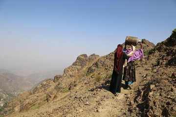 Yemeni children bring food and drink on bumpy mountain roads due to the siege and war on the city...