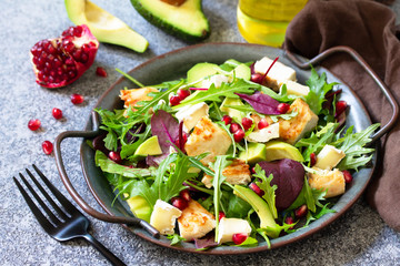 Salad with grilled chicken, avocado, brie cheese, arugula and pomegranate with vinaigrette dressing.
