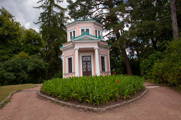 Beautiful nature landscape park with green herbs and trees, big stones and little river with waterfall in summer