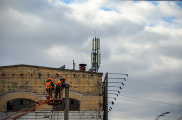 Electrical worker dismantling the wires on the pole with the help of the lift car