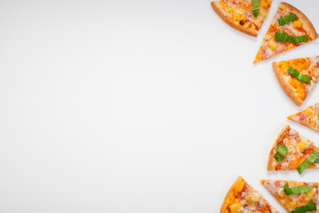 Pieces of pizza, with herbs, are located on a white background, with copy space. Concept of ordering pizza at home.