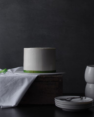 Buttercream cake with a green ribbon on a wood crate