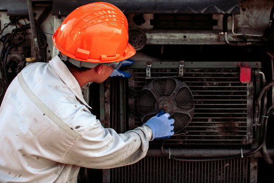 The mechanic is checking the radiator fan. Of large truck engines