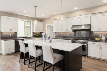 Kitchen in new home with stainless steel appliances, island, and pendant lights