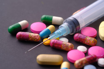 syringe and pills on table, drug abuse 