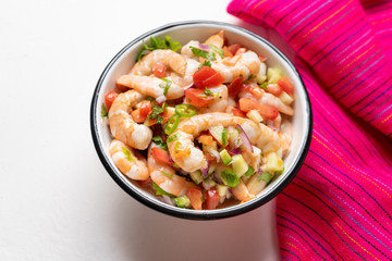 Mexican shrimp ceviche with tomato and serrano pepper on white background