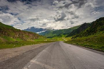 An empty road in the middle of beautiful mountains.