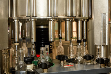 Factory for the production of alcoholic beverages. On the conveyor, vodka is bottled.