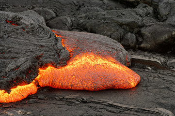 Detailed view of an active lava flow, hot magma emerges from a crack in the earth, the glowing lava appears in strong yellows and reds - Hawaii, Big Island, Kilauea volcano, Puna district, Kalapana