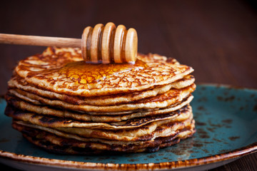 Thin pancakes, crepes with   honey on wooden background.  Pancake week, mardi gras, maslenitsa holidays