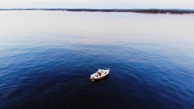 AERIAL: Little fishing boat goes back to land. Beautiful blue water. Sunset vibes. Umag, Croatia