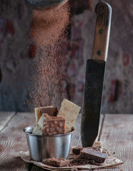 white and black chocolate on a wooden table with orange and knife