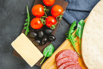 Process of making pizza round dough with black olives, cherry tomatoes, mozzarella cheese, sliced...