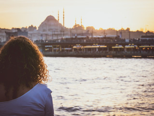 Young female girl is watching to istanbuls Galata bride durig the sunset surounded by water. Lifestyle and culture in Turkey conception. © Evaldas
