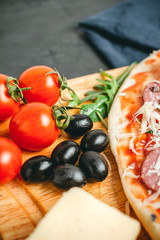 Red cherry tomatoes, black olives, close-up view, ingredients to pizza cooking homemade