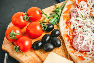 Red cherry tomatoes, black olives, close-up view, ingredients to pizza cooking homemade