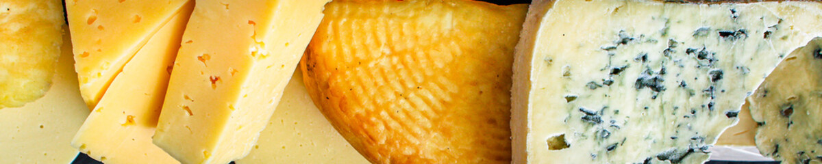 cheese background, many different types pieces on a dark (cheese product) menu concept background. top view. copy space