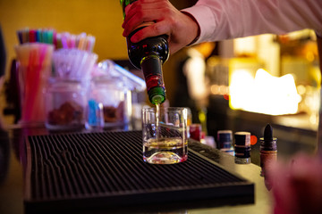 Close up a barman hand is serving a glass of whiskey