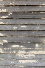 A wooden siding wall background with peeling white paint