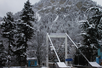 View of snowy mountains and bridge over Kura river in Borjomi