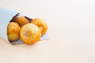 French doughnuts Beignet covered with sugar powder on a brown background