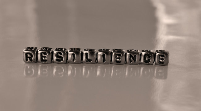 Resilience -  word from metal blocks - concept sepia tone photo on shine background