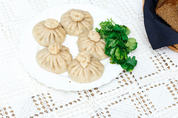 cooked khinkali on a white Cup on a serving table
