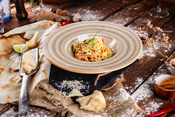 Pasta Carbonara with Parmesan cheese and sauce on a plate on a wooden background