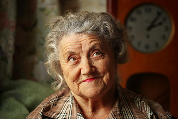 Looking elderly woman portrait with kind eyes on a dark background