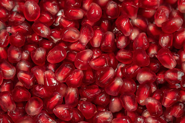 Close up of fresh organic pomegranate seeds. food background. Ripe red berries.