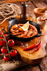 Fototapeta na wymiar Fried large shrimp in tomato sauce with olive oil, garlic, cilantro and soy sauce, next ingredients for cooking