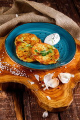 Fototapeta na wymiar Close-up view of potato pancakes. Potato cake on a blue plate on a wooden table
