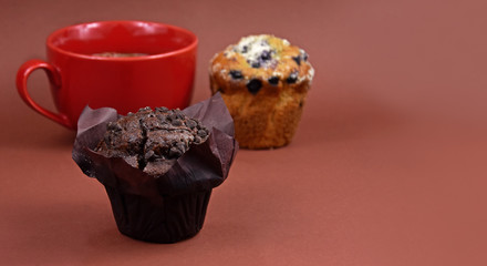 Chocolate muffin stock images. Chocolate muffin isolated on a brown background with copy space for text. Various muffins and cup of coffee stock images. Chocolate muffin frame. Breakfast still life