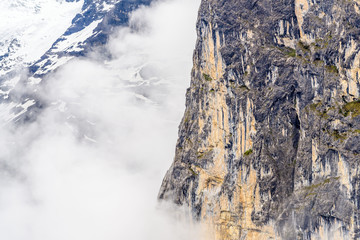 Fototapeta na wymiar The Swiss Alps at Murren, Switzerland. Jungfrau Region. Tops of the mountains in fog and clouds.