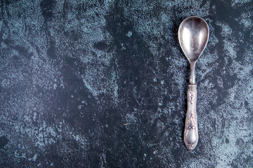 Vintage silver spoon on a grundge blue background