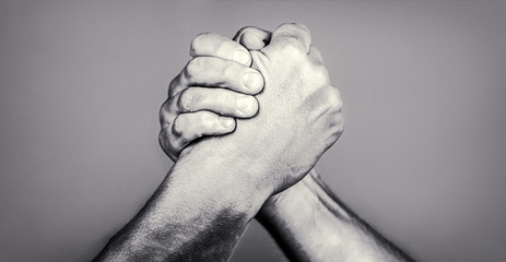 Two men arm wrestling. Arms wrestling. Friendly handshake, friends greeting. Handshake, arms, friendship. Hand, rivalry, vs, challenge, strength comparison. Closep up. Black and whit