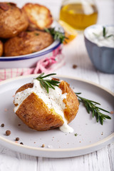 Whole potato roasted with rosemary and spices, served with sour cream sauce. Vegetarian dish. 