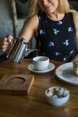Blondie long hair woman is having lunch in a restaurant in the middle of the day.