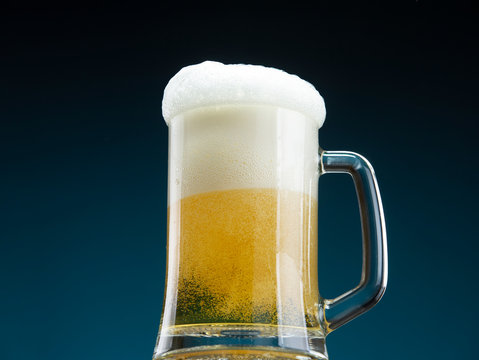 Foam snowdrift on a beer mug. Beer mug filled with fresh beer
