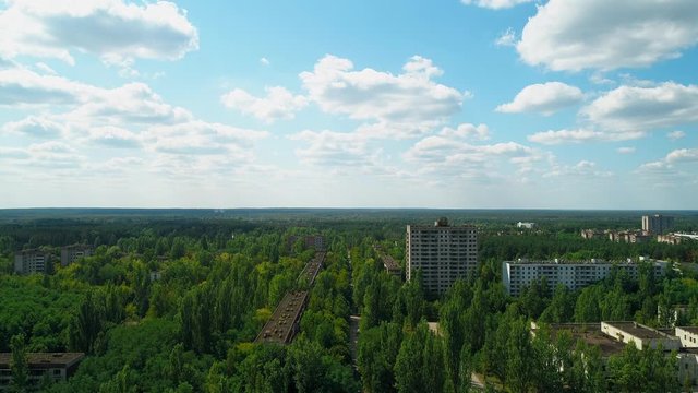 Aerial view of abandoned buildings and streets overgrown with trees in city Pripyat near Chernobyl nuclear power plant. Exclusion Zone. Sign of USSR on the roof. 4K drone footage.