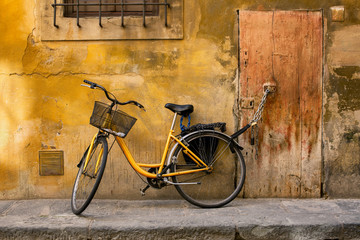 Fototapeta na wymiar Yellow bicycle chained to a door handle