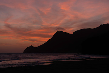 Sonnenuntergang spanische Küste, Bucht mit Felsen, Burg
