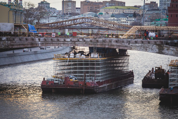 Process of repairing the massive bridge with construction pontoon barge, river equipment and cranes...