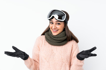 Skier girl with snowboarding glasses over isolated white wall with shocked facial expression