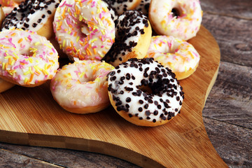 assorted donuts with chocolate frosted, pink glazed and sprinkles donuts. delicious snack
