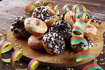 holiday donuts with colorful party streamers and confetti on rustic background