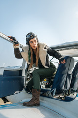 the girl the pilot sits looks at the end of the plane from the cockpit with the side panel on his head, the pilot's helmet and glasses © nikitaat